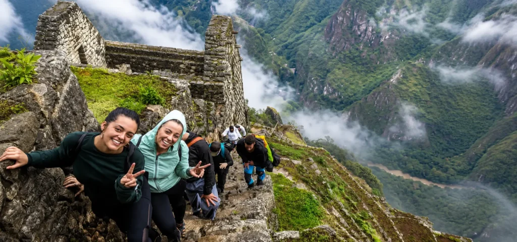 Hikers climbing the steep stone steps of the Huayna Picchu trail